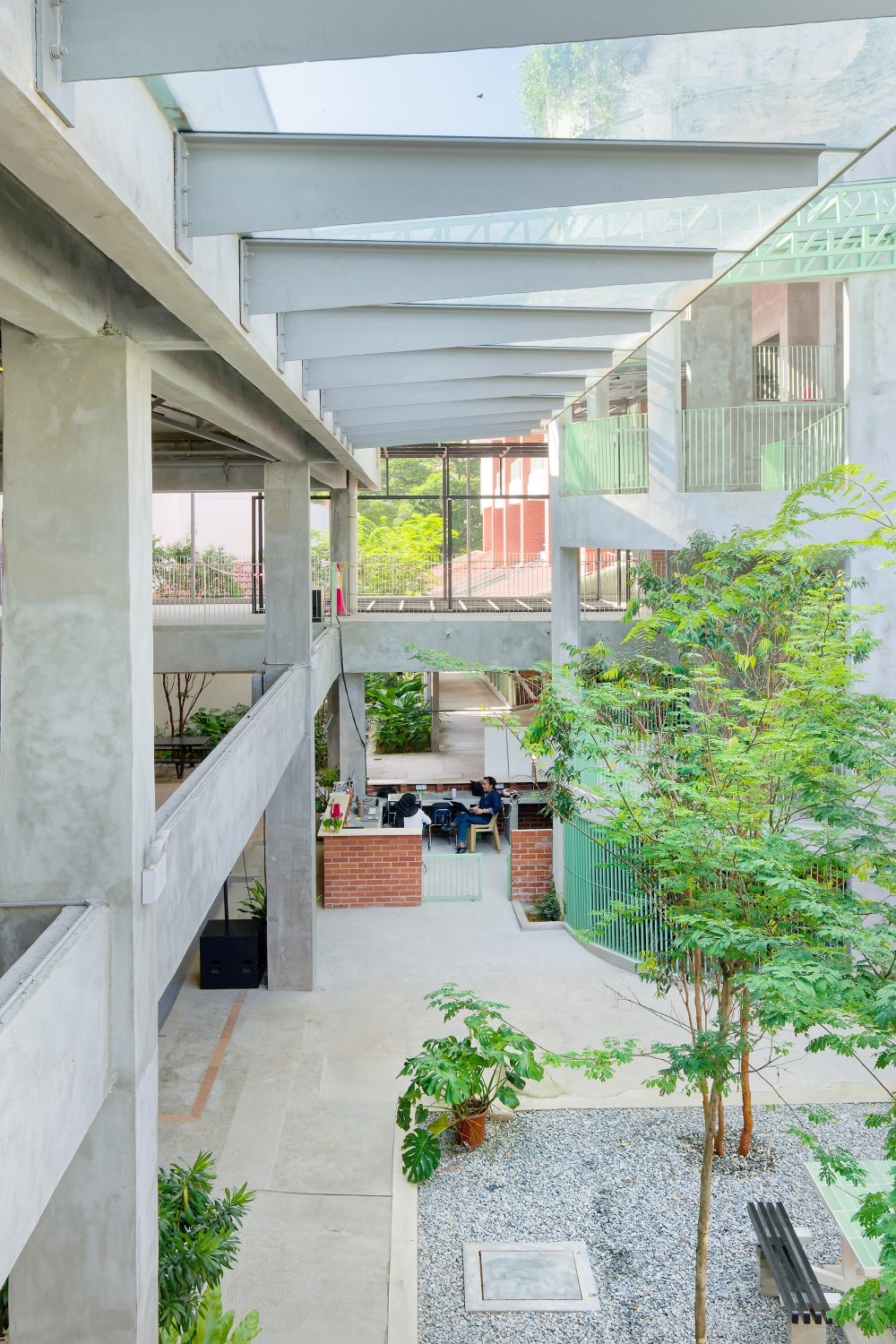 Planted courtyard at The Campus, concrete walkways and green railings