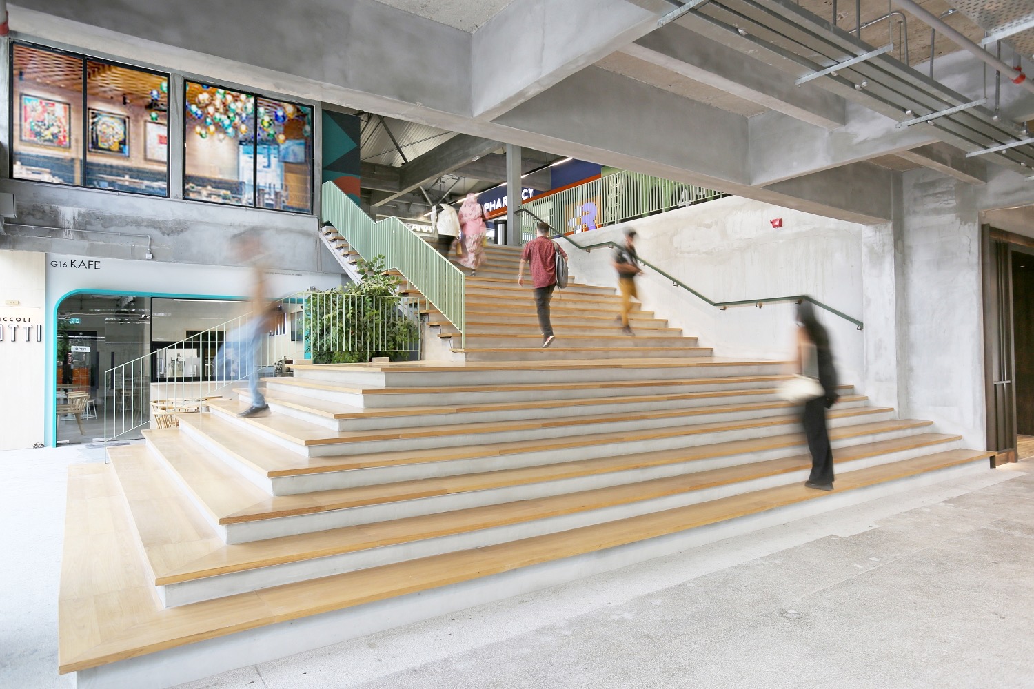Wide timber steps inside The Campus with people walking past cafes