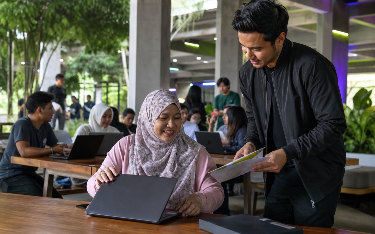 A volunteer handing a participant her starter-kit pack at a shared table